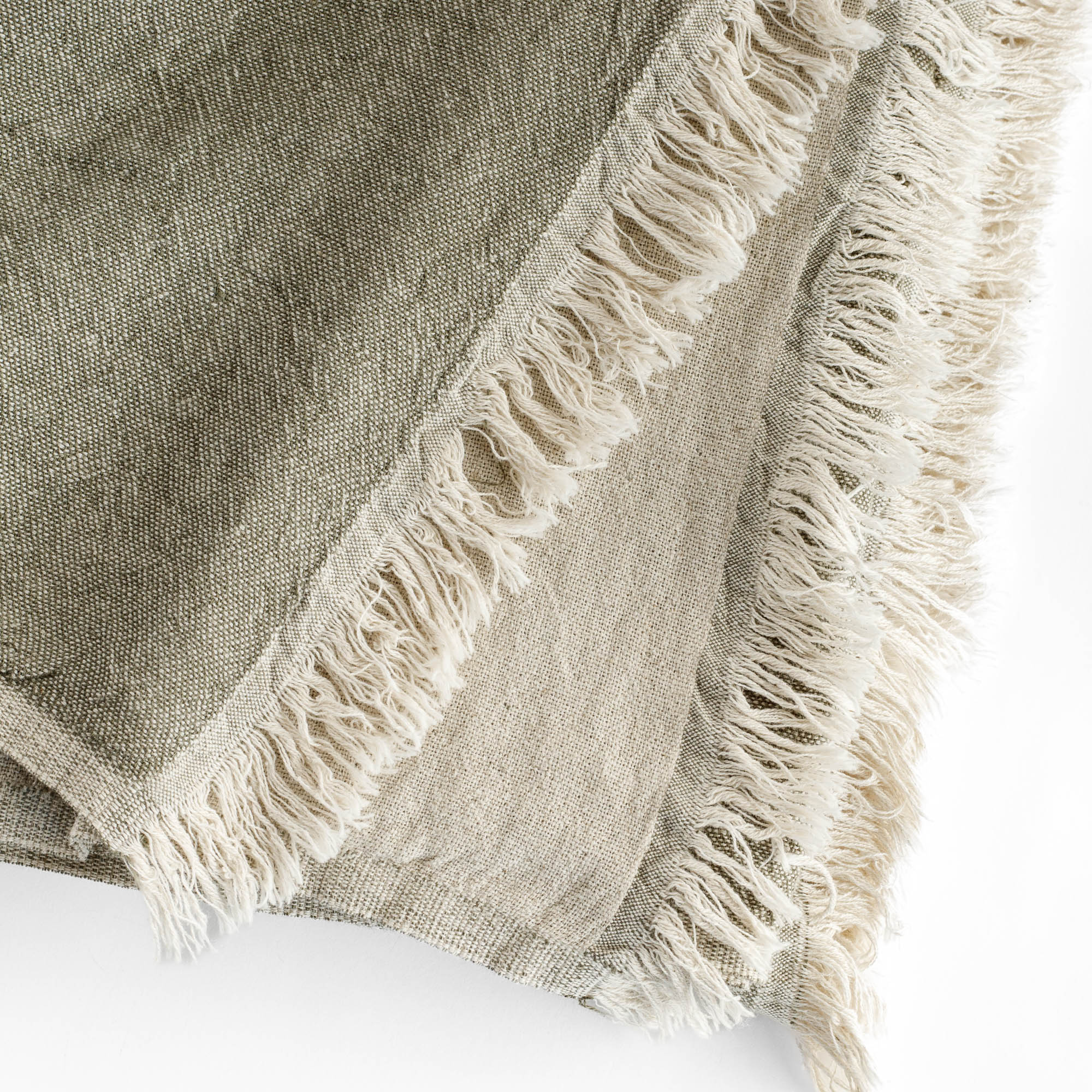 an olive green and natural linen cotton throw blanket with a delicate fringe edge : close up view