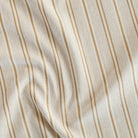 a beige, cream, ochre yellow and tan brown striped home decor fabric