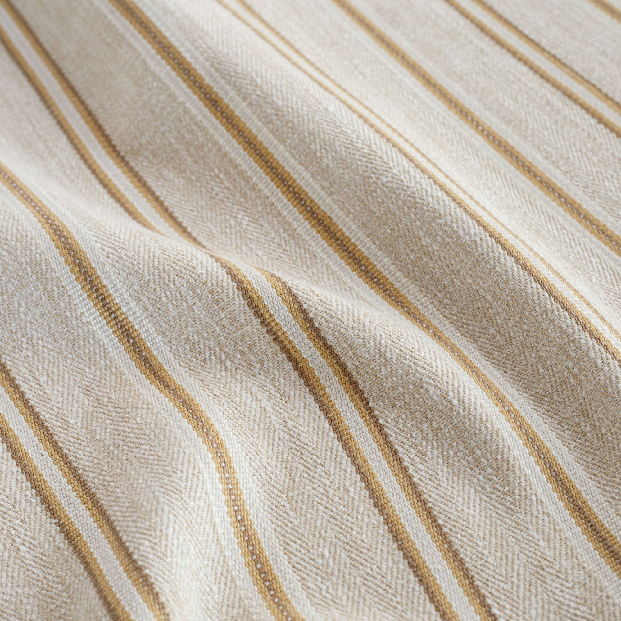 a beige, cream, ochre yellow and tan brown striped upholstery fabric