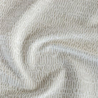 Avani Sand, a cream and tan high-performance fabric from Tonic Living with a pattern of imperfect broken lines.