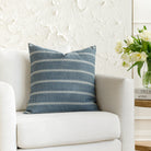 A blue throw pillow from Tonic Living, styled on furniture.