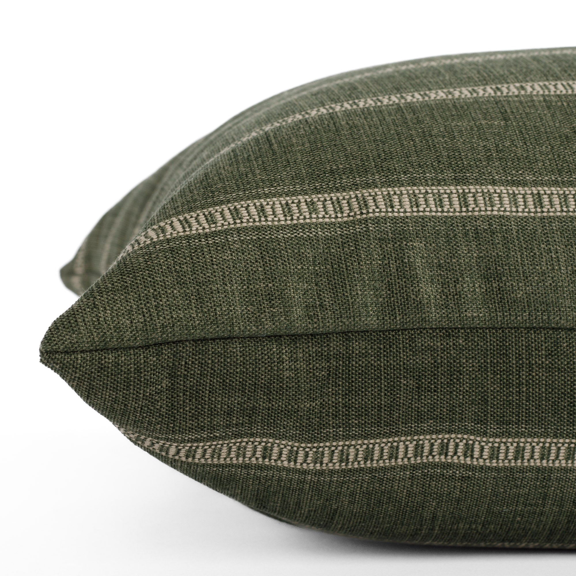 A green and white throw pillow: close up side view.