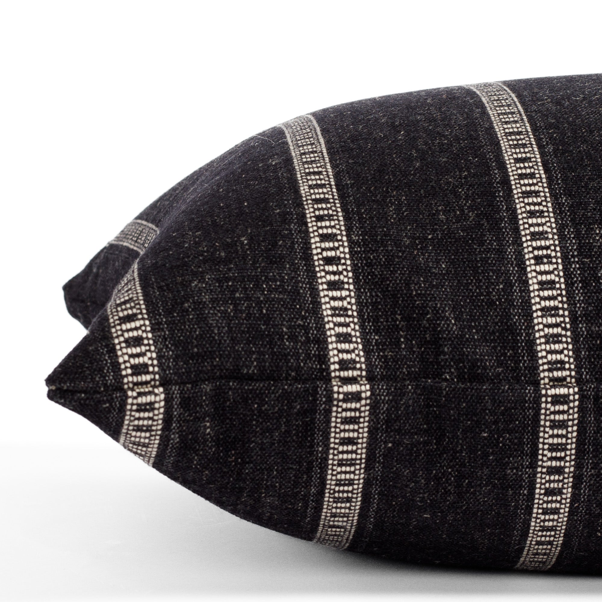 A black and white striped lumbar pillow: close up side view.