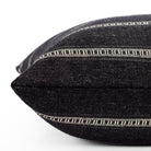 A black and white striped pillow: close up side view.