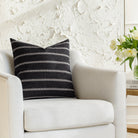 A black and white pillow from Tonic Living, styled on furniture.