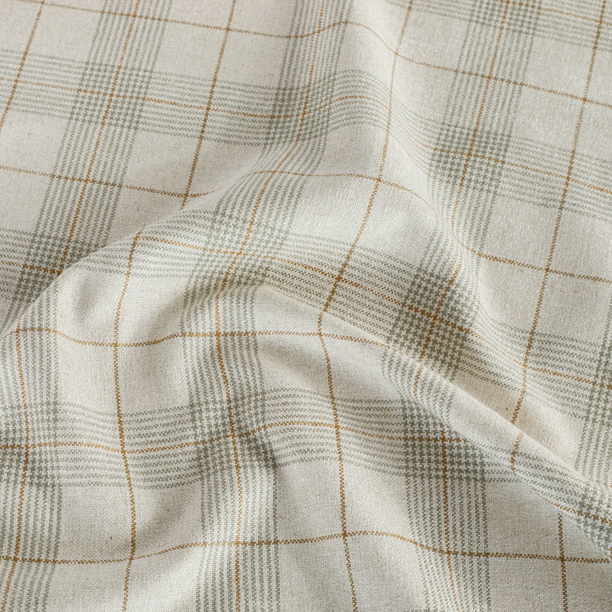 a beige, brown and sage green woven plaid patterned upholstery fabric from Tonic Living