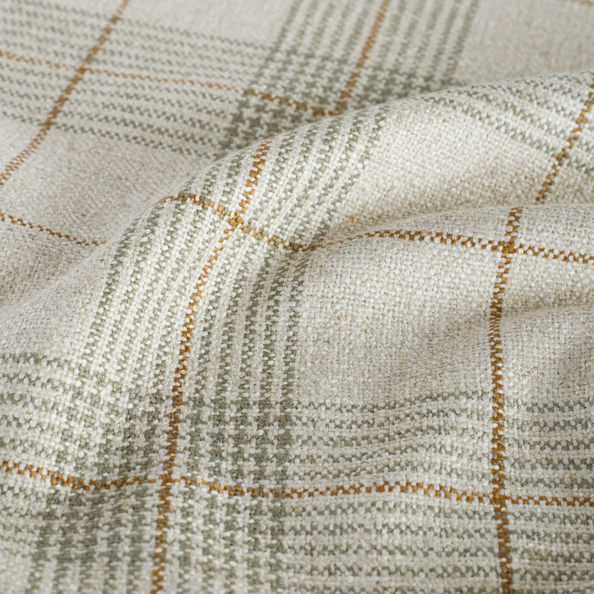 an oatmeal, caramel and green woven plaid patterned upholstery fabric : close up view