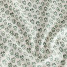 A warm white linen-blend fabric with green flowers, a home decor fabric from Tonic Living.