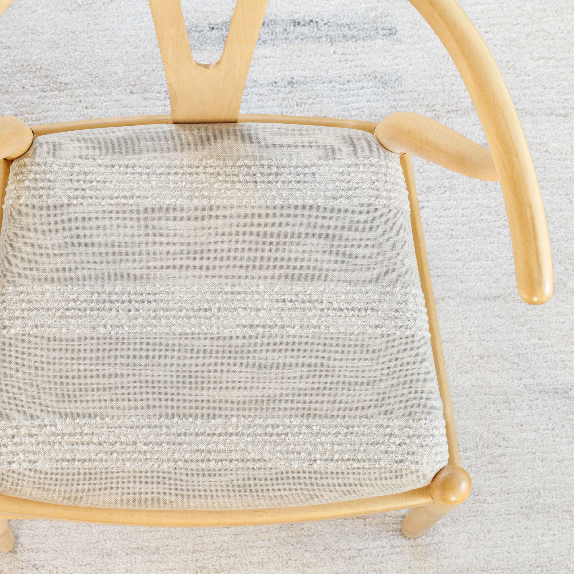 an oatmeal and off white loopy stripe fabric upholstered chair seat