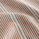 a rust red, parchment and black stripe home decor fabric : close up view