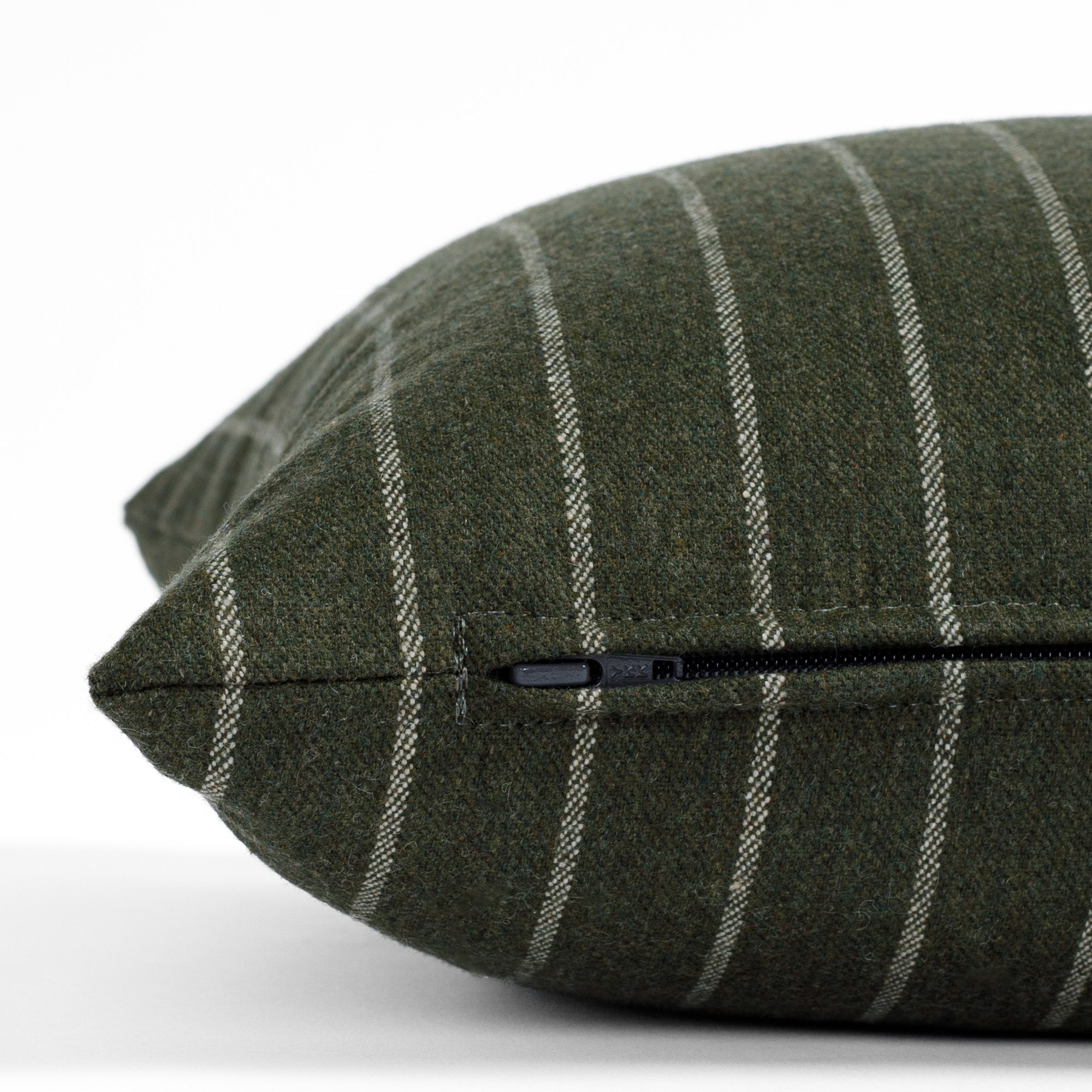 a hunter green and cream striped lumbar pillow: close up zipper view