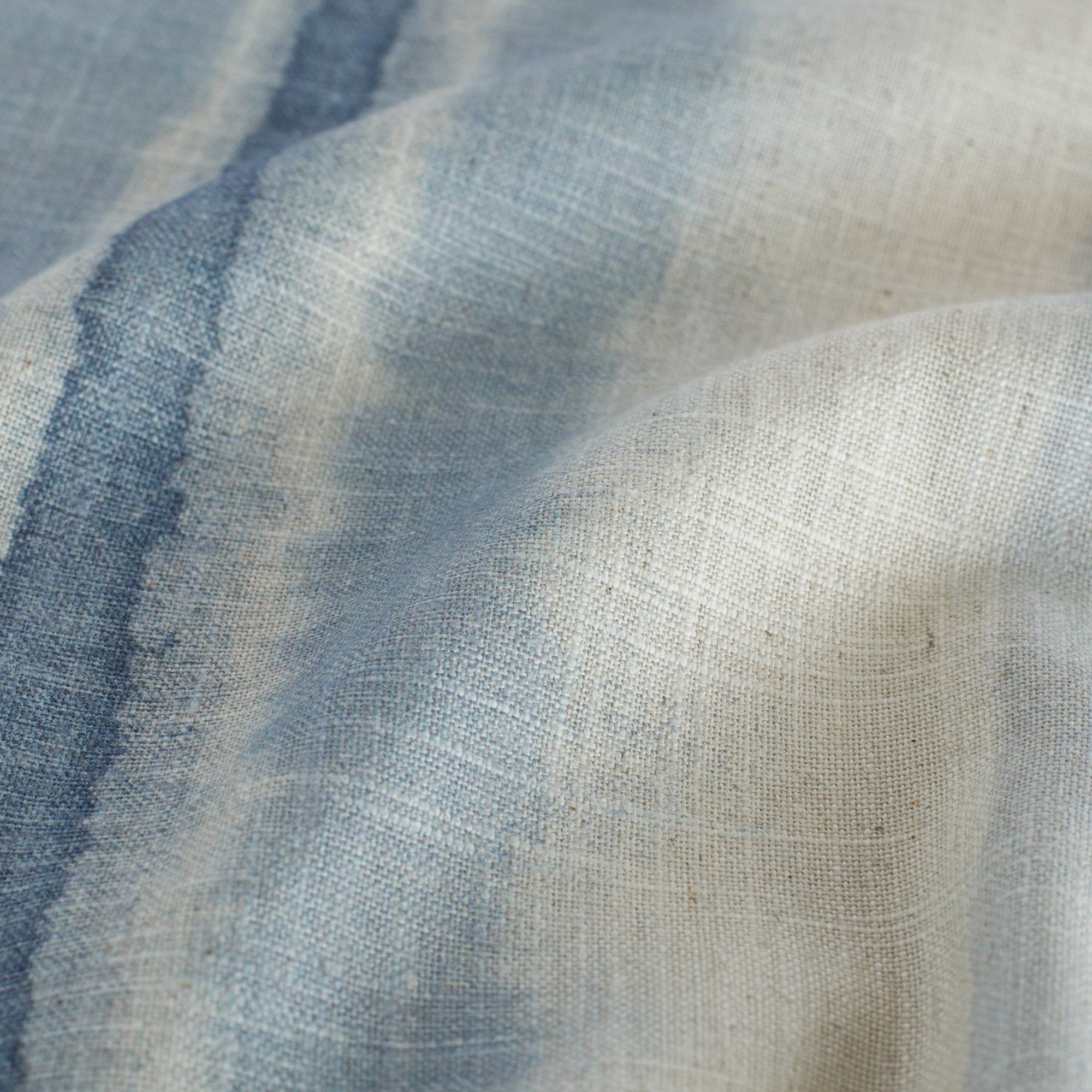 a painterly blue ombre stripe print drapery fabric : close up view