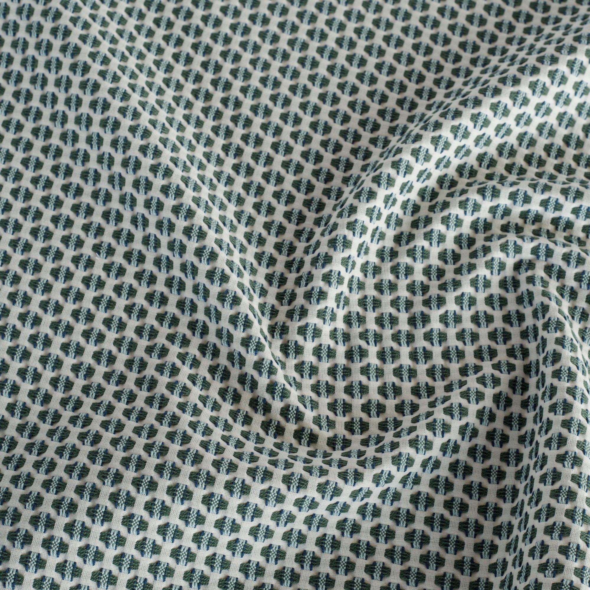 a cream, blue and green intricate woven small scaled geometric patterned home decor fabric from Tonic Living