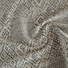 A black and tan Tonic Living upholstery fabric featuring a pattern of softly worn dots and lines.