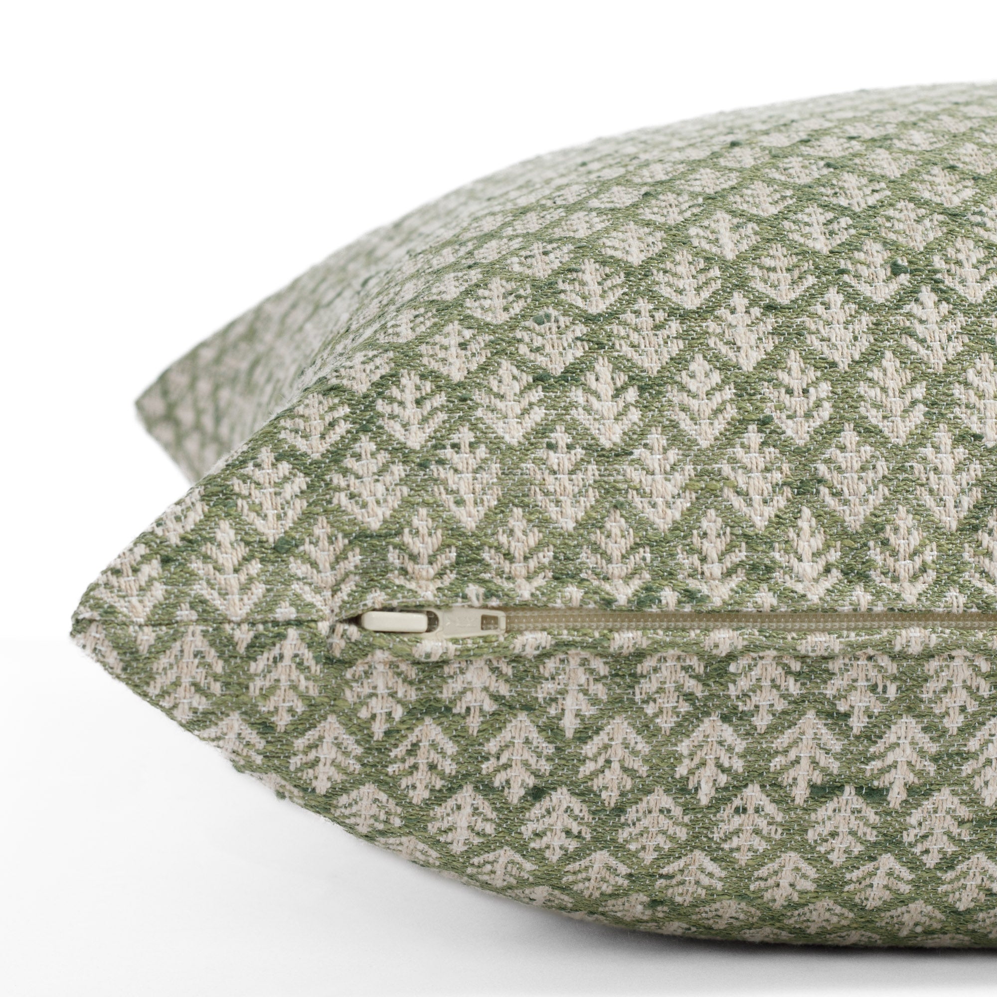 Leaf green and beige pillow with frond pattern: close up zipper view.