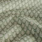 a pine green, botanical leaf-patterned fabric : close up view