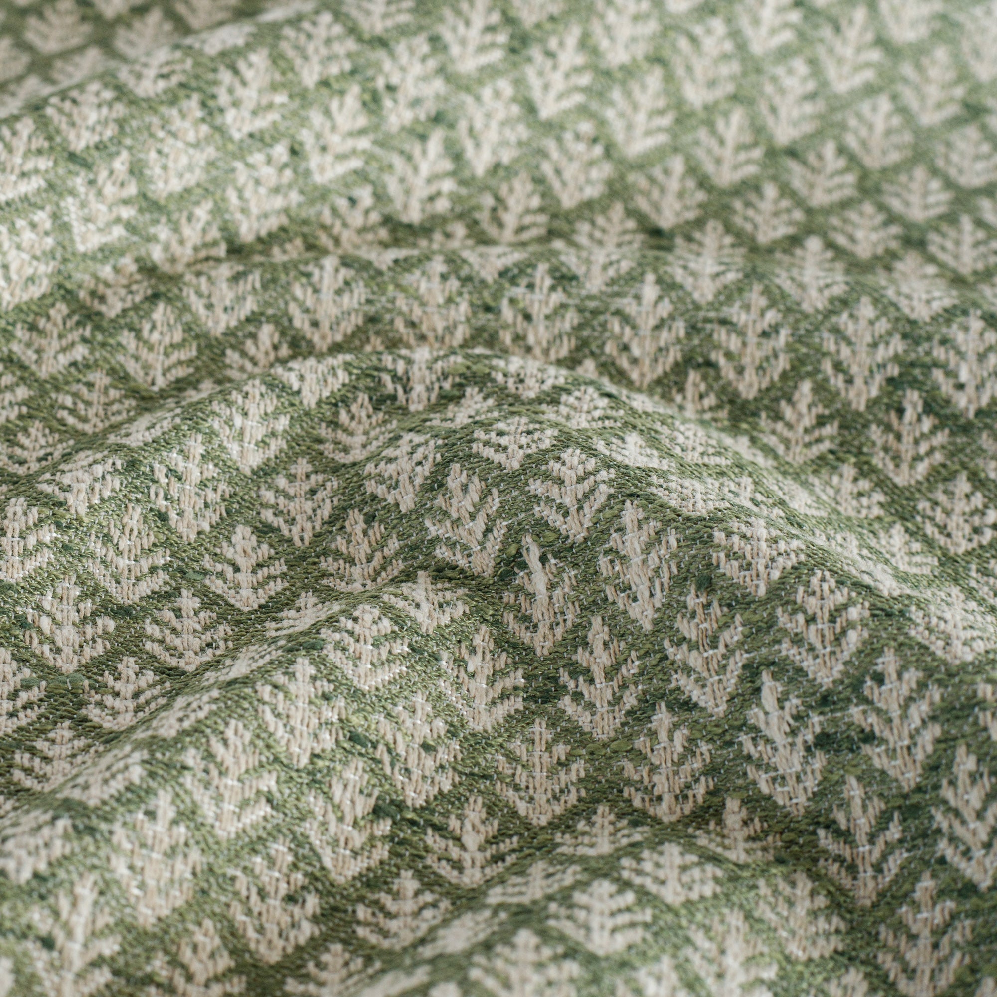 a pine green, botanical leaf-patterned fabric : close up view