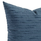 A faded navy blue pillow with textured tonal stripes: close up view.