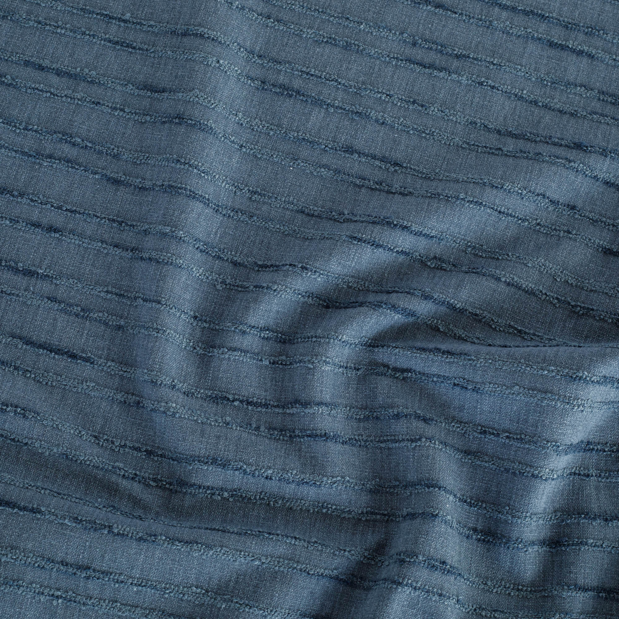 a navy blue upholstery fabric with a textured bouclé stripe