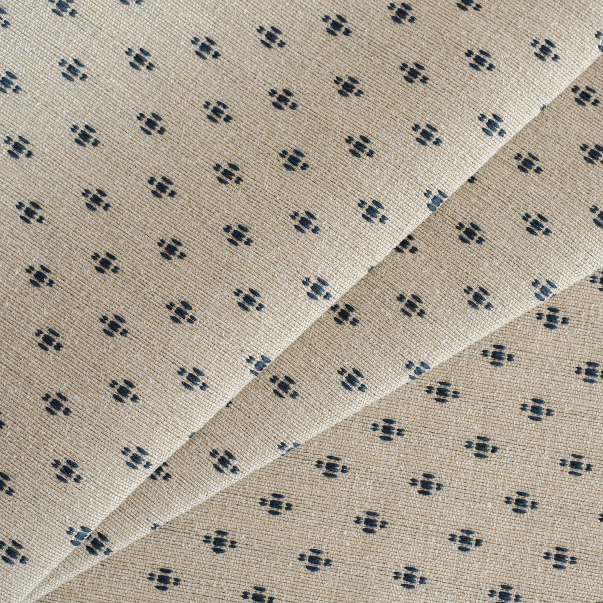 This taupe and navy blue high-performance upholstery fabric is tightly woven with a small-scale pattern of raised dashes.