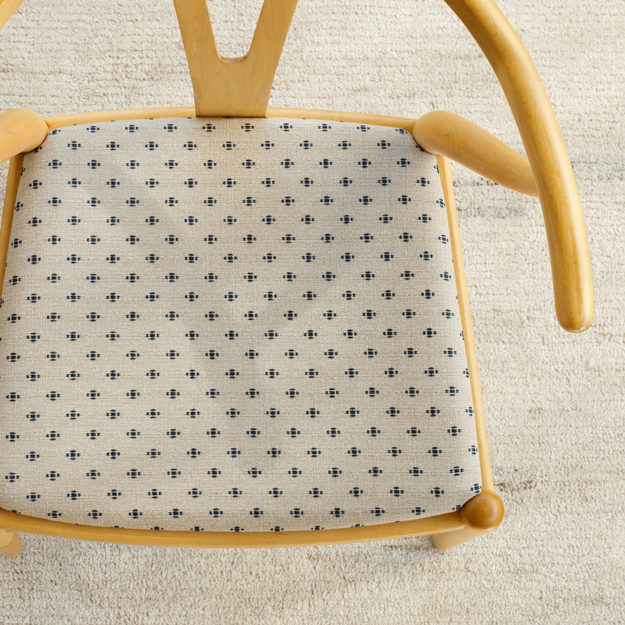 An upholstery fabric from Tonic Living with a taupe and navy blue dot and dash pattern in a staggered arrangement.