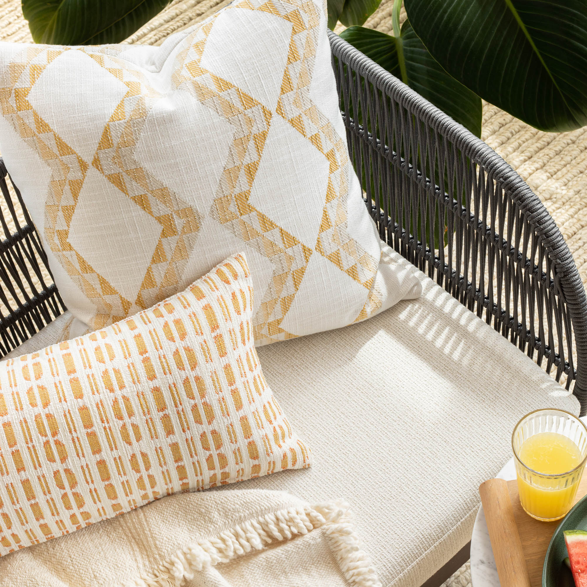 Outdoor vignette :  modern graphic patterned white and yellow outdoor pillow from Tonic Living in gold hues